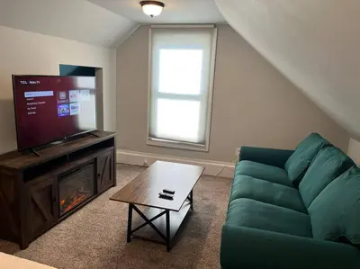 a living room with a green couch and a television at Main, Three Bedroom House in Historic Loveland in Loveland