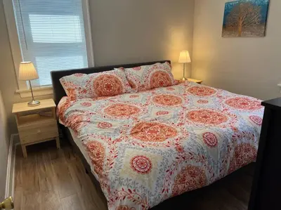 a bed with a flowered comforter and pillows in a bedroom at Warren 1 Bedroom Unit near Xavier Downtown in Bellevue