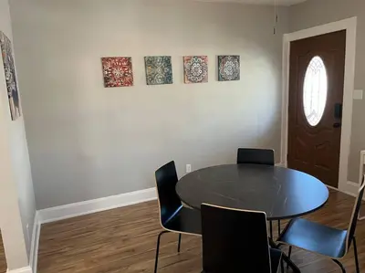 a dining room with a table and chairs and a door at Warren 1 Bedroom Unit near Xavier Downtown in Bellevue
