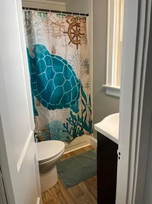 a bathroom with a toilet and a shower curtain at Warren 1 Bedroom Unit near Xavier Downtown in Bellevue