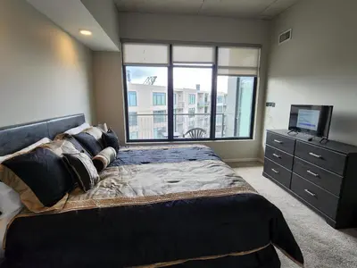 a bedroom with a large bed and a television at Penthouse Loft In The Flats in Cleveland