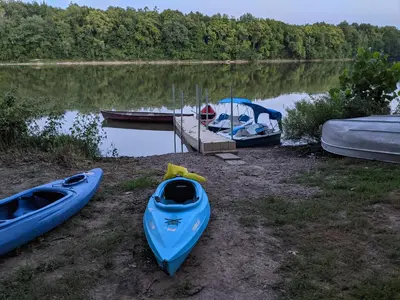 three kayaks are parked on the shore of a lake at River Log Cabins in Waterville
