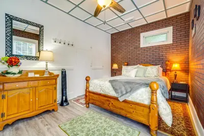 a bedroom with a bed and a brick wall at Quaint Mt Vernon Cottage Near Historic Dtwn! in Mount Vernon