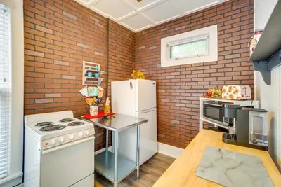 a kitchen with brick walls and a white refrigerator at Quaint Mt Vernon Cottage Near Historic Dtwn! in Mount Vernon