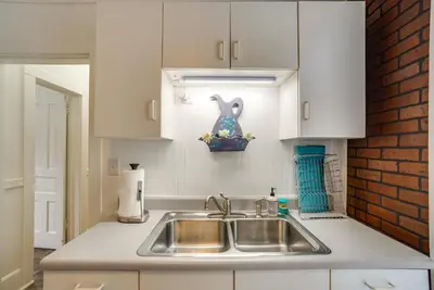 a kitchen with a sink and a brick wall at Quaint Mt Vernon Cottage Near Historic Dtwn! in Mount Vernon