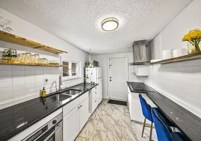 a kitchen with a sink and a refrigerator at Tremont! 7 min to downtown Cleveland in Cleveland