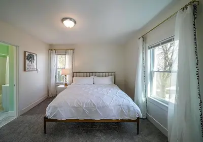 a white bedroom with a bed and a window at Tremont! 7 min to downtown Cleveland in Cleveland