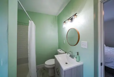 a bathroom with a sink and a toilet and a mirror at Tremont! 7 min to downtown Cleveland in Cleveland