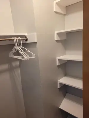a closet with white shelves and a hanger at dock, game room, bar and private river view patio in Toledo