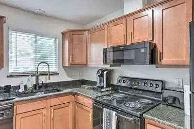 a kitchen with wooden cabinets and a stove top oven at Welcoming Ohio Getaway Less Than 9 Mi to Dtwn Toldeo! in Toledo