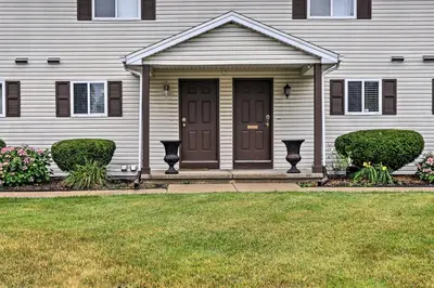 a house with a brown door and a yard at Welcoming Ohio Getaway Less Than 9 Mi to Dtwn Toldeo! in Toledo