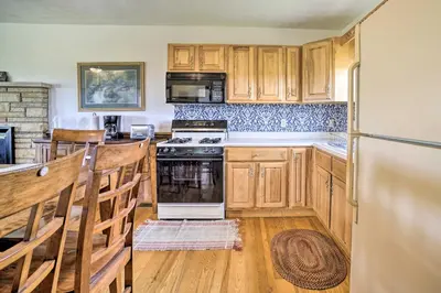a kitchen with wooden cabinets and a stove and refrigerator at McArthur Cabin Peaceful Getaway on Farm! in McArthur