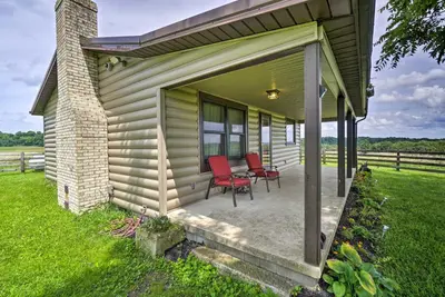 a house with two red chairs on a patio at McArthur Cabin Peaceful Getaway on Farm! in McArthur
