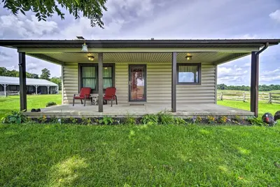 a small yellow house with two red chairs on a porch at McArthur Cabin Peaceful Getaway on Farm! in McArthur