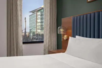 a bedroom with a white bed and a window at Hotel Ardent Dayton Downtown, Tapestry Collection By Hilton in Dayton