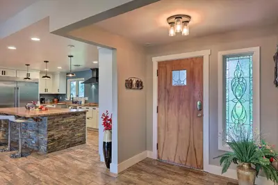 a kitchen with a wooden door and a counter at Peaceful Lebanon FarmhouseandRanch with Pool! in Lebanon