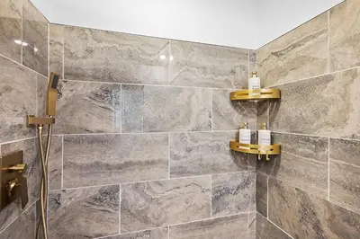 a bathroom with a shower with marble tiles at Center of Little Italy #1 in Cleveland