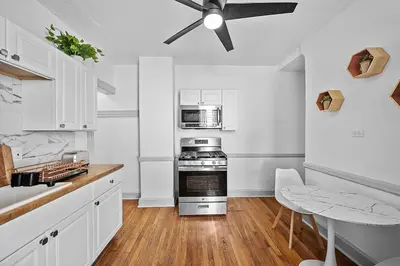 a kitchen with a stove and a ceiling fan at Center of Little Italy #1 in Cleveland