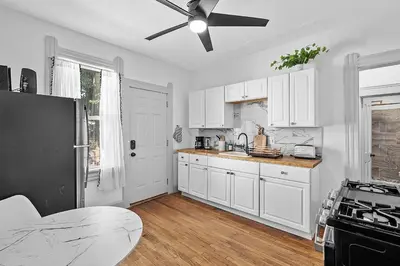 a kitchen with white cabinets and a ceiling fan at Center of Little Italy #1 in Cleveland
