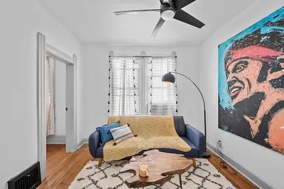 a living room with a couch and a painting on the wall at Center of Little Italy #1 in Cleveland