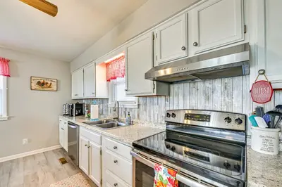 a kitchen with white cabinets and a stove top oven at Welcoming Kentucky Home with Sprawling Views! in Corinth