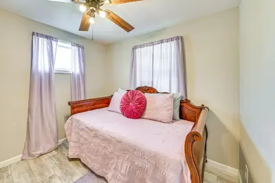 a bedroom with a bed with pink sheets and a ceiling fan at Welcoming Kentucky Home with Sprawling Views! in Corinth
