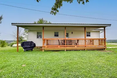 a house with a large deck on a yard at Welcoming Kentucky Home with Sprawling Views! in Corinth