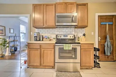 a kitchen with wooden cabinets and a stove top oven at Convenient Columbus Retreat, 2 Mi to Downtown in Columbus