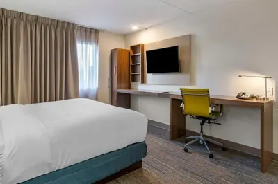 a hotel room with a bed and a desk with a computer at MainStay Suites Lexington I-75 in Lexington