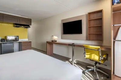 a room with a bed and a desk and a television at MainStay Suites Lexington I-75 in Lexington