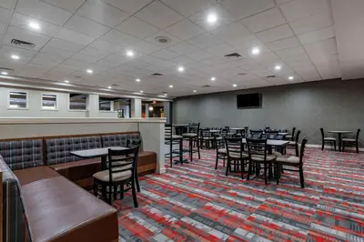 a restaurant with tables and chairs in a room at MainStay Suites Lexington I-75 in Lexington