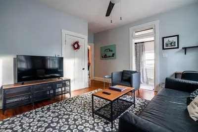 a living room with a couch and a flat screen tv at Historic Comfy German Village Haus sleeps6petsOK in Columbus