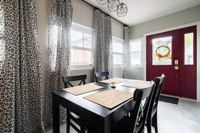 a dining room with a table and chairs and a red door at Historic Comfy German Village Haus sleeps6petsOK in Columbus