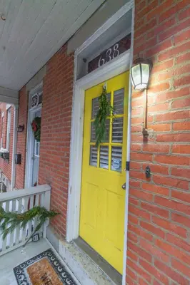 a yellow front door of a brick house at Walkable And Cozy German Village Hauspets Ok in Columbus