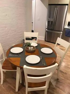 a dining room table with white chairs and a kitchen at Spacious 1 bed 1 bath Downtown OTR condo minutes walk to the Reds Bengals stadium & more! in Cincinnati