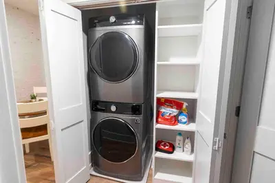 a washer and dryer sitting in a closet at Spacious 1 bed 1 bath Downtown OTR condo minutes walk to the Reds Bengals stadium & more! in Cincinnati