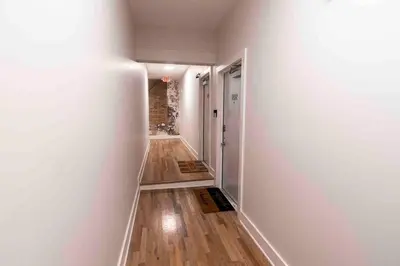 an empty hallway with white walls and wood floors at Spacious 1 bed 1 bath Downtown OTR condo minutes walk to the Reds Bengals stadium & more! in Cincinnati