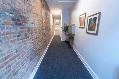 a hallway with a brick wall next to a hallway sidx sidx at Spacious 1 bed 1 bath Downtown OTR condo minutes walk to the Reds Bengals stadium & more! in Cincinnati