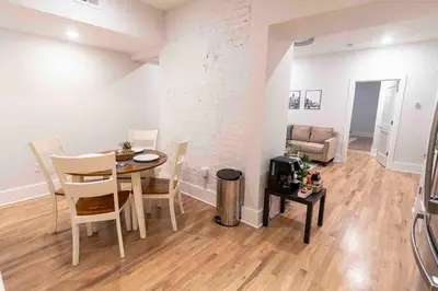 a living room with a table and a room with a couch at Spacious 1 bed 1 bath Downtown OTR condo minutes walk to the Reds Bengals stadium & more! in Cincinnati
