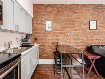 a kitchen with a brick wall and a counter top at Cute German Village LilHausCity ParkPetsOK in Columbus
