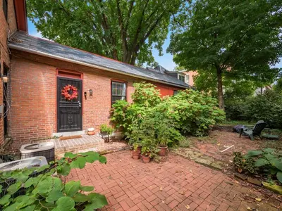 a brick house with a brick yard with plants at Cute German Village LilHausCity ParkPetsOK in Columbus