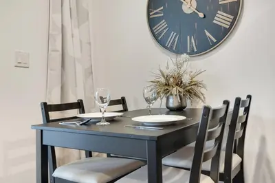 a black table with chairs and a clock on the wall at Magnolia Suite - Main Street Lodge in Berlin in Berlin