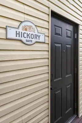 a sign on the side of a house with a door at Hickory Suite - Main Street Lodge in Berlin in Berlin