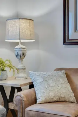 a lamp sitting on a table next to a couch at Hickory Suite - Main Street Lodge in Berlin in Berlin