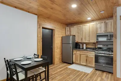a kitchen with a table and a black refrigerator at Hickory Suite - Main Street Lodge in Berlin in Berlin