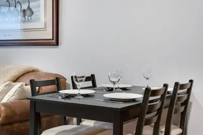 a black dining room table with glasses on it at Hickory Suite - Main Street Lodge in Berlin in Berlin
