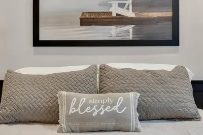 a pillow sitting on top of a bed with a picture at Hickory Suite - Main Street Lodge in Berlin in Berlin