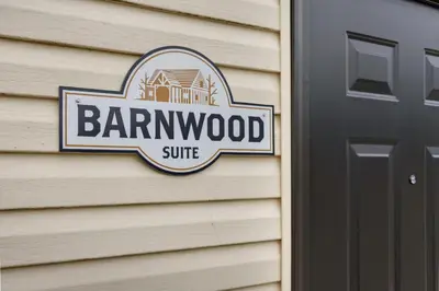 a barn wood sign on the side of a house at Barnwood Suite - Main Street Lodge in Berlin in Berlin