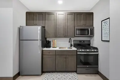 a kitchen with wooden cabinets and a white refrigerator at Barnwood Suite - Main Street Lodge in Berlin in Berlin