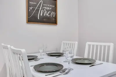 a white table with plates and wine glasses and a chalkboard at Barnwood Suite - Main Street Lodge in Berlin in Berlin